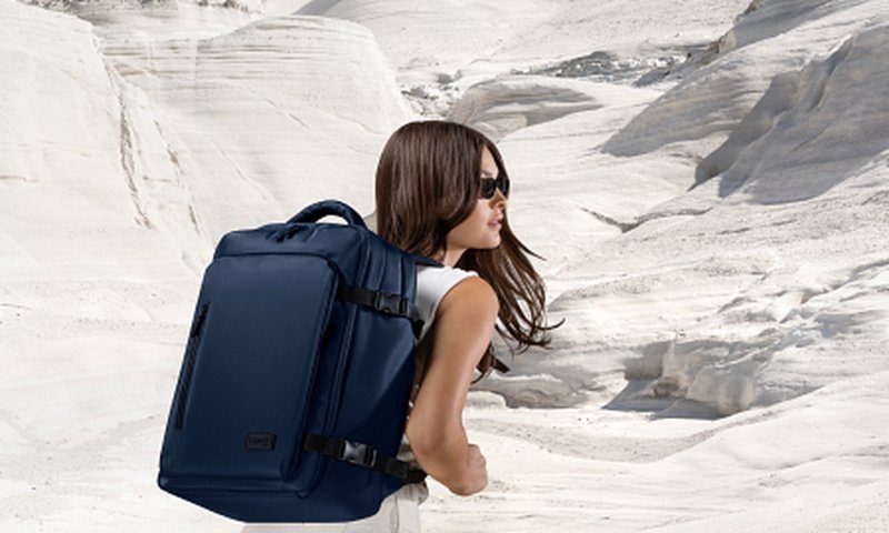Femme portant un sac à dos de voyage dans un paysage désertique lors d’un road trip