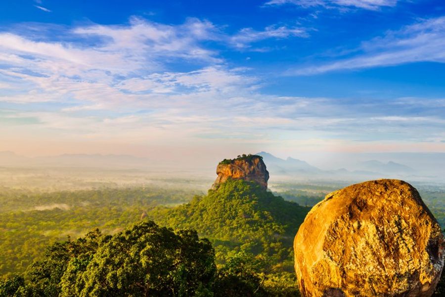 Vue panoramique sur le rocher de Pidurangala, entouré de végétation luxuriante au Sri Lanka.