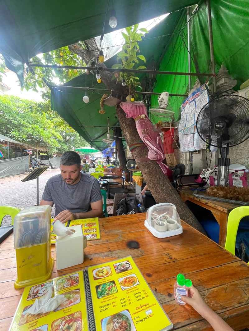 Cyril lisant un menu à une table près d
