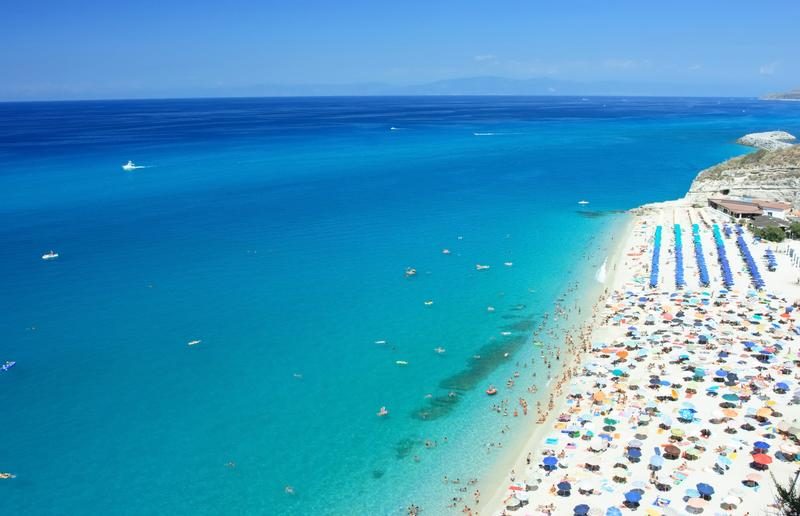 Plages animées de Tropea avec sable fin et parasols colorés.