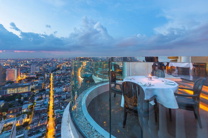 Vue panoramique depuis un bar en rooftop avec une table dressée.