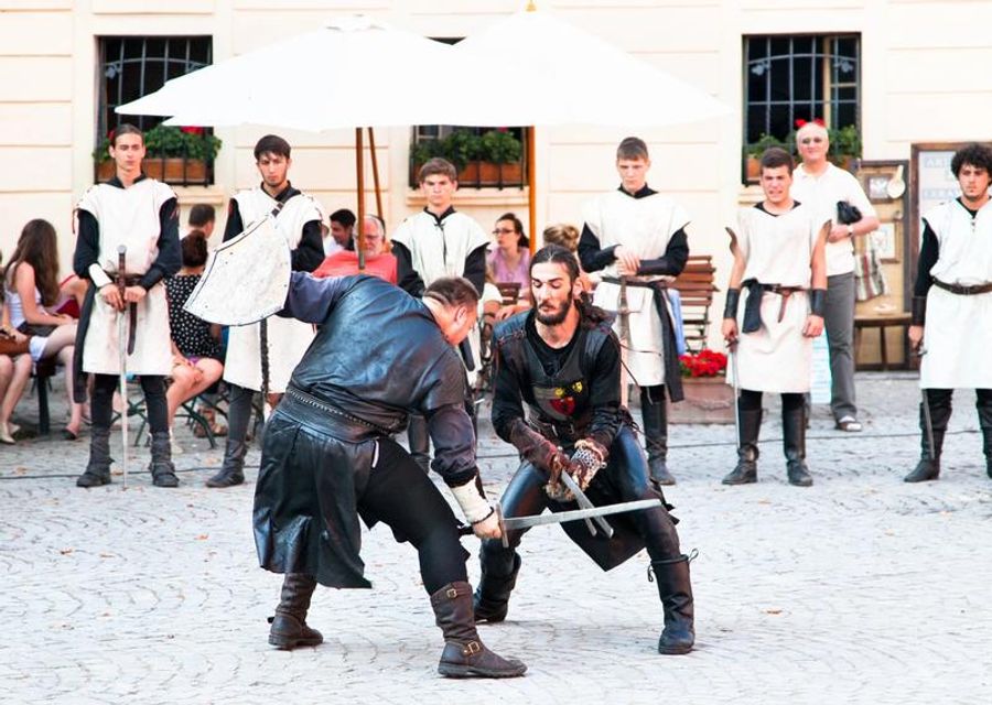 Démonstration de combat médiéval avec des acteurs costumés.