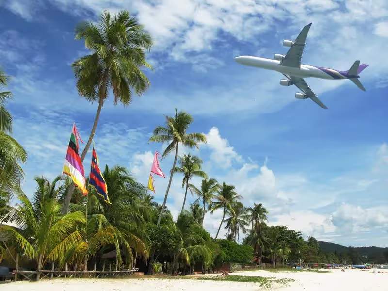 Un avion qui survol une plage de Malaisie