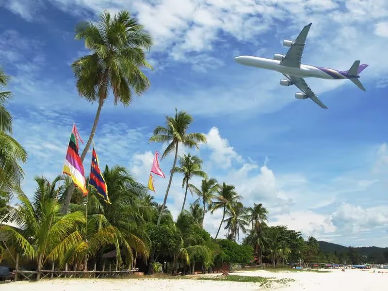 Un avion qui survol une plage de Malaisie