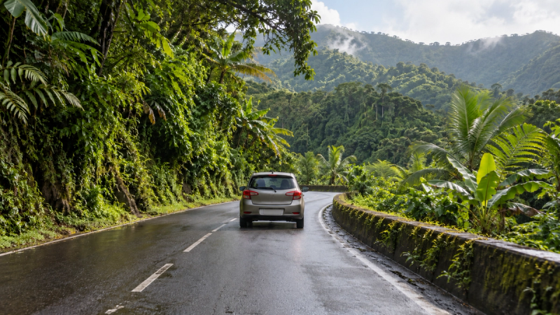 Voiture sans logo roulant sur une route tropicale de Basse-Terre en Guadeloupe