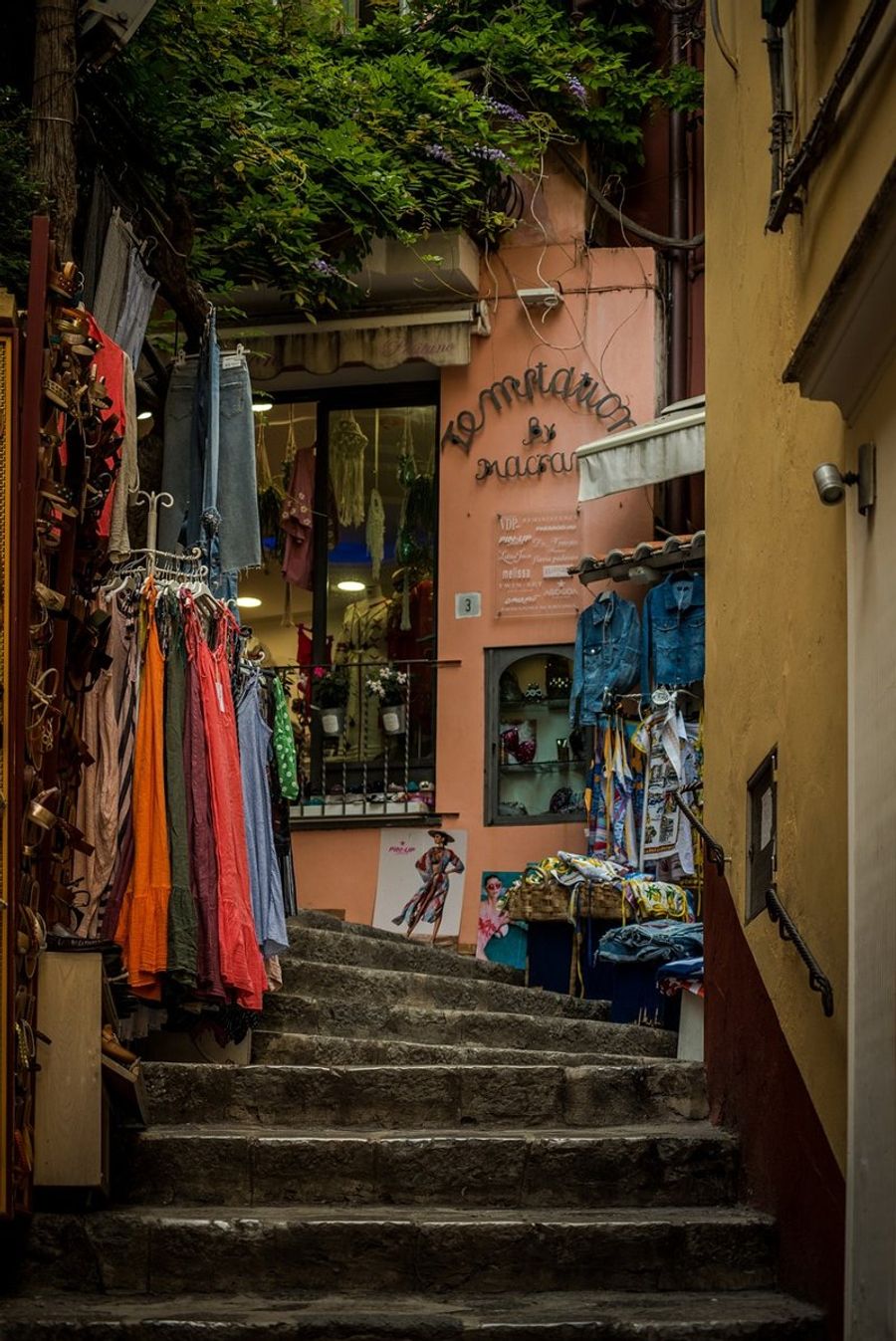 Une ruelle pittoresque de Positano avec des boutiques de vêtements.
