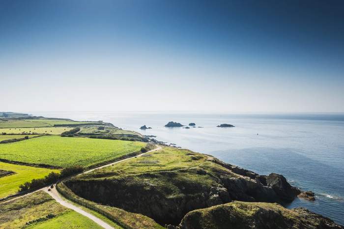 Vue aérienne d’une côte sauvage en Bretagne avec falaises, sentiers et horizon marin dégagé