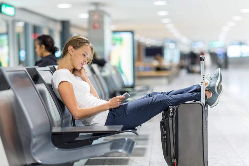 Femme qui joue sur le téléphone à l'aéroport