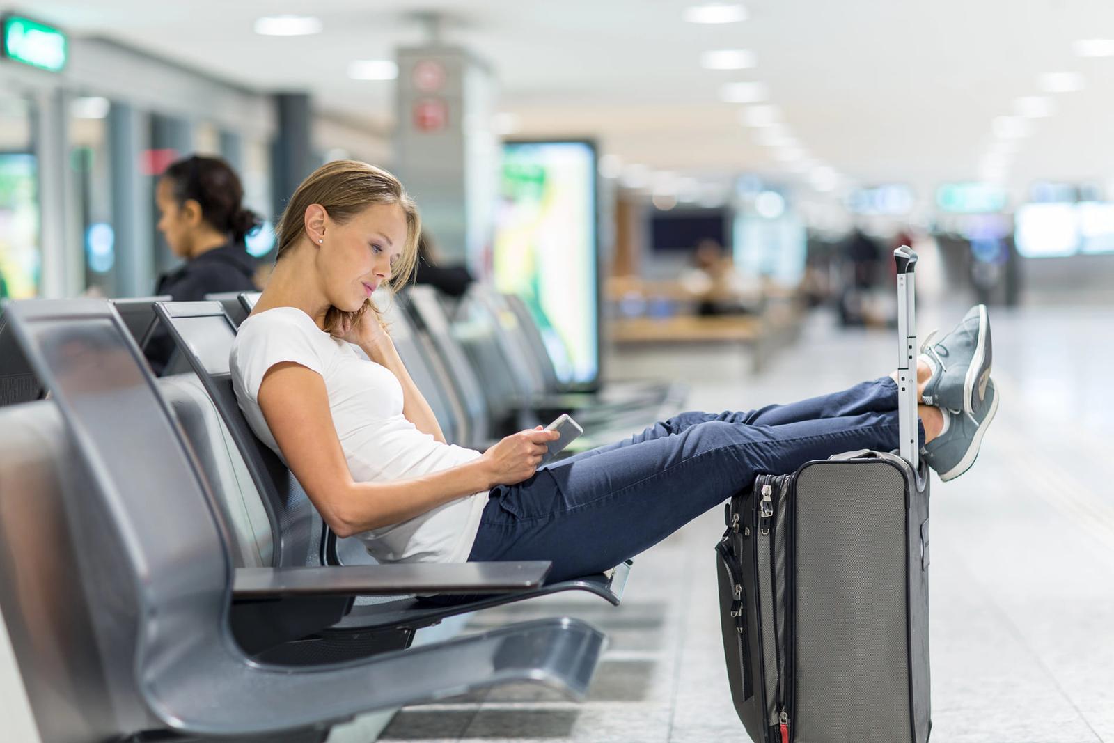 Femme qui joue sur le téléphone à l'aéroport