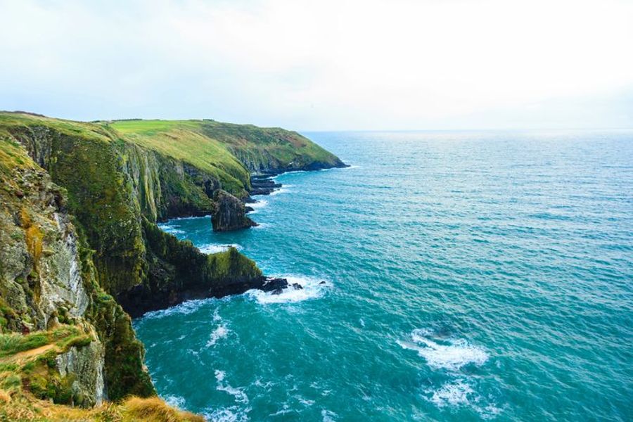 Vue spectaculaire des falaises verdoyantes plongeant dans l’océan près de Cork, en Irlande.