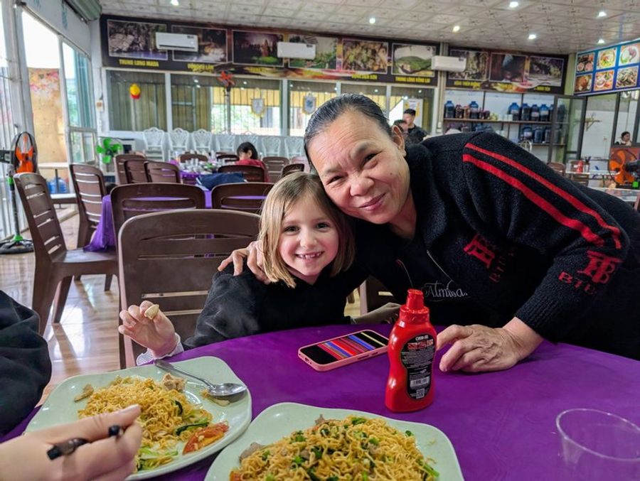 Moment convivial dans le restaurant Nha Hang Am Thuc 73 à Phong Nha, avec la propriétaire et un plat de nouilles
