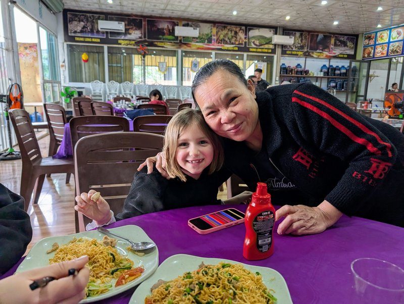 Moment convivial dans le restaurant Nha Hang Am Thuc 73 à Phong Nha, avec la propriétaire et un plat de nouilles