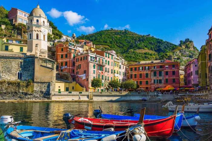 Vue pittoresque de Cinque Terre en Italie avec des maisons colorées et des bateaux amarrés sur l'eau.