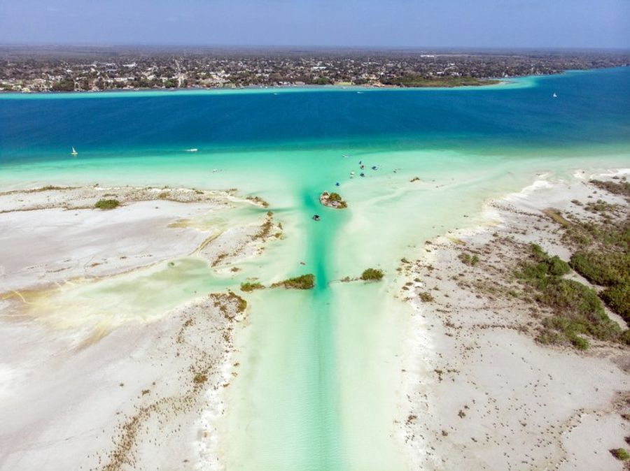 Vue aérienne de la lagune de Bacalar, connue pour ses eaux cristallines et ses différentes nuances de bleu.