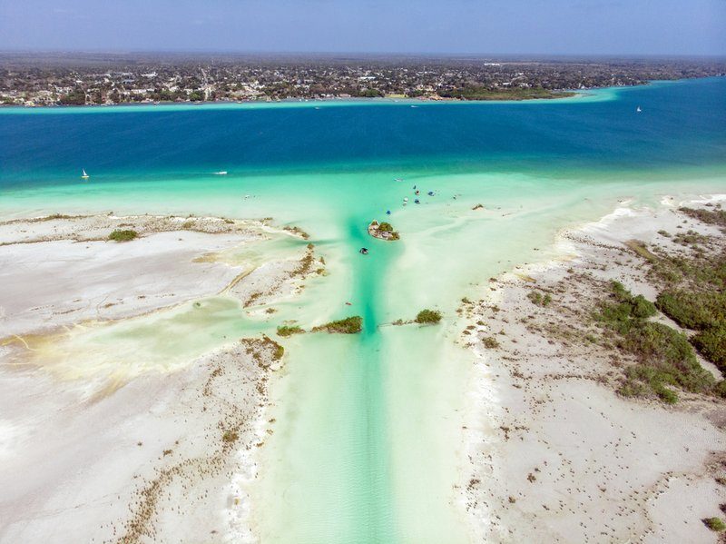 Vue aérienne de la lagune de Bacalar, connue pour ses eaux cristallines et ses différentes nuances de bleu.