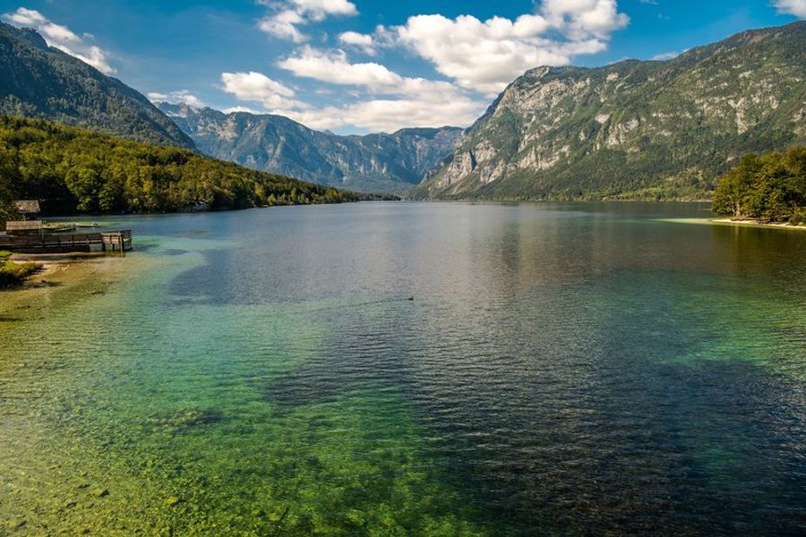 Vue panoramique du lac de Bohinj encadré par les sommets des Alpes juliennes en Slovénie, aux eaux limpides et turquoise