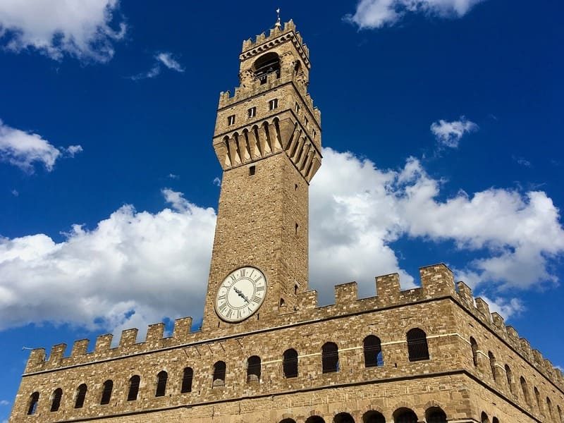 La tour imposante du Palazzo Vecchio à Florence, avec son horloge emblématique et son architecture médiévale.