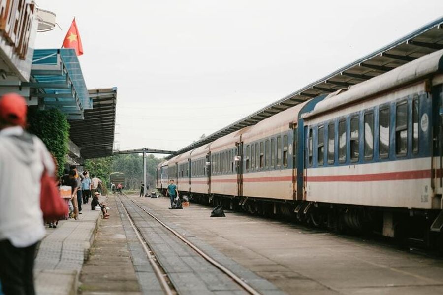 Une vue d’une gare ferroviaire au Vietnam avec un drapeau vietnamien en arrière-plan. 