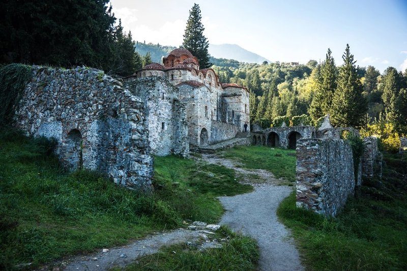 Ruines de la ville basse de Mystra entourées de verdure.