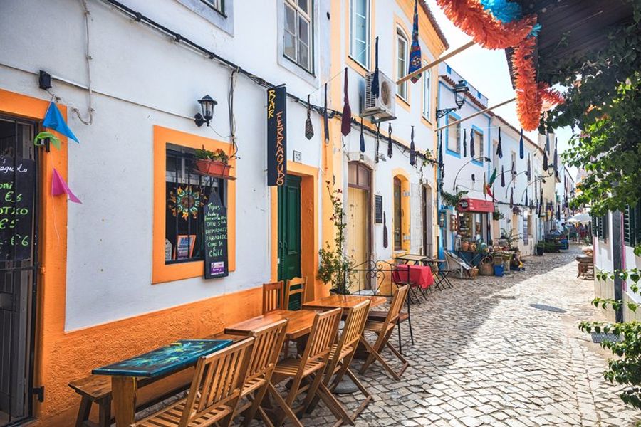 Ruelles pittoresques de Ferragudo avec des maisons colorées et des terrasses de cafés.