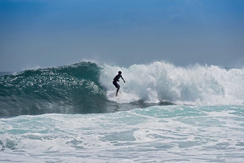 Surfeur chevauchant une vague imposante sur les plages renommées de Nosara, Costa Rica.