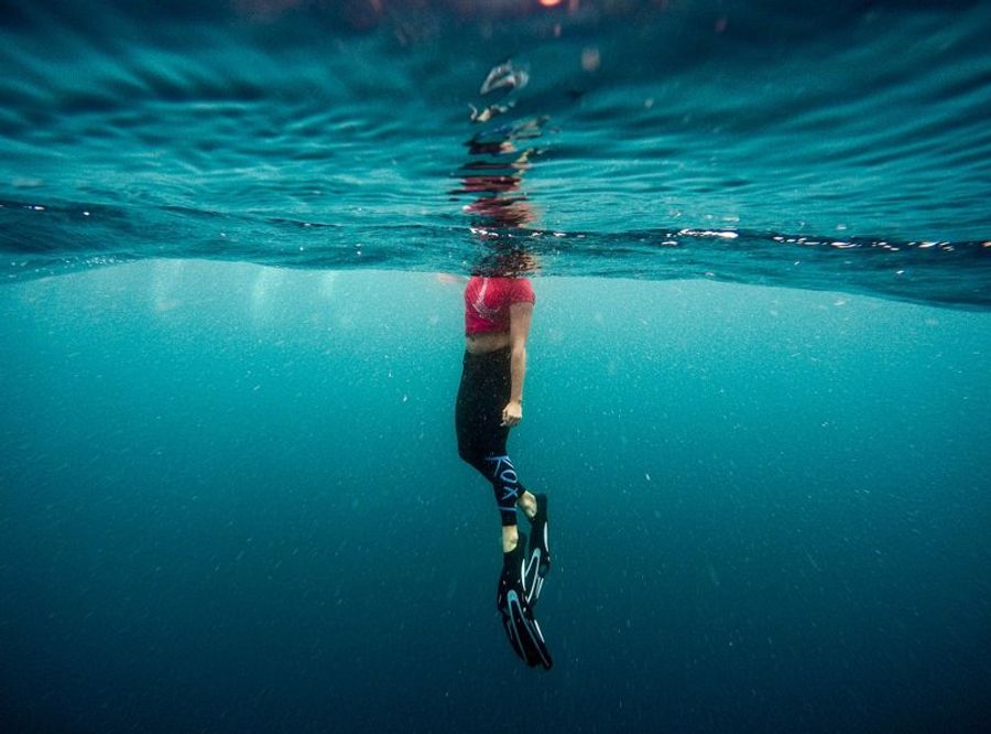Une personne en tenue de plongée flottant juste sous la surface de l