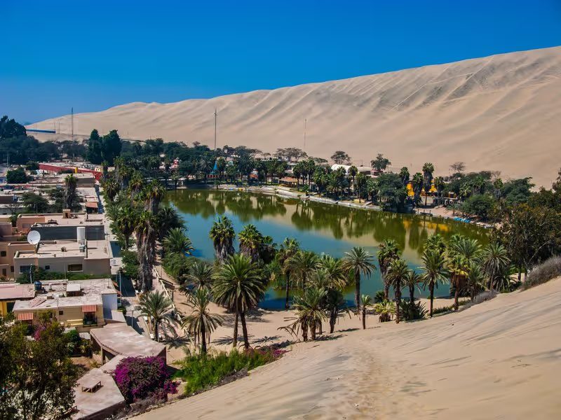 Oasis de Huacachina entourée de dunes de sable dans le désert péruvien.