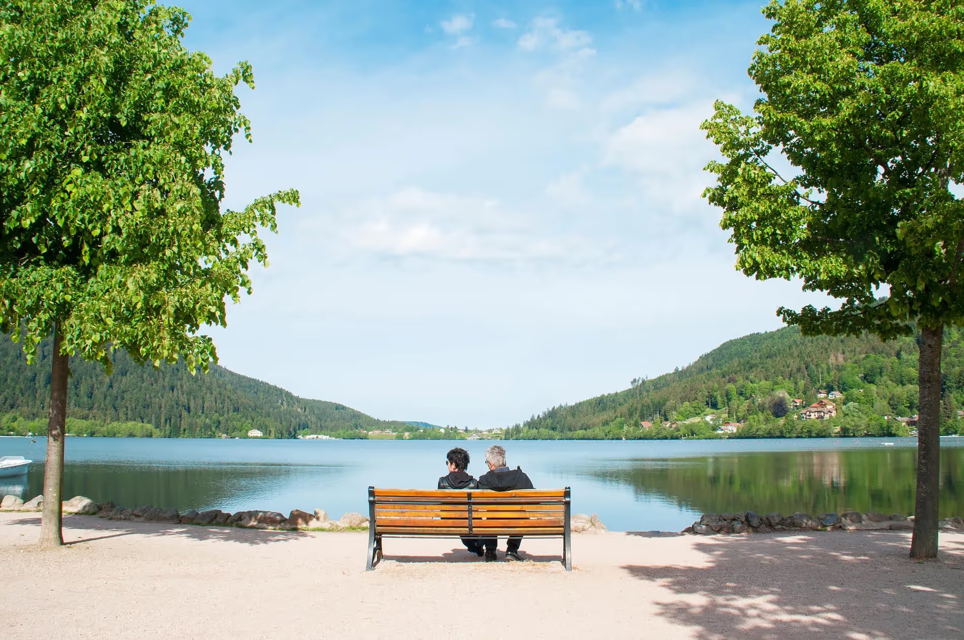 Des personnes assises sur un banc en face du lac de Gérardmer