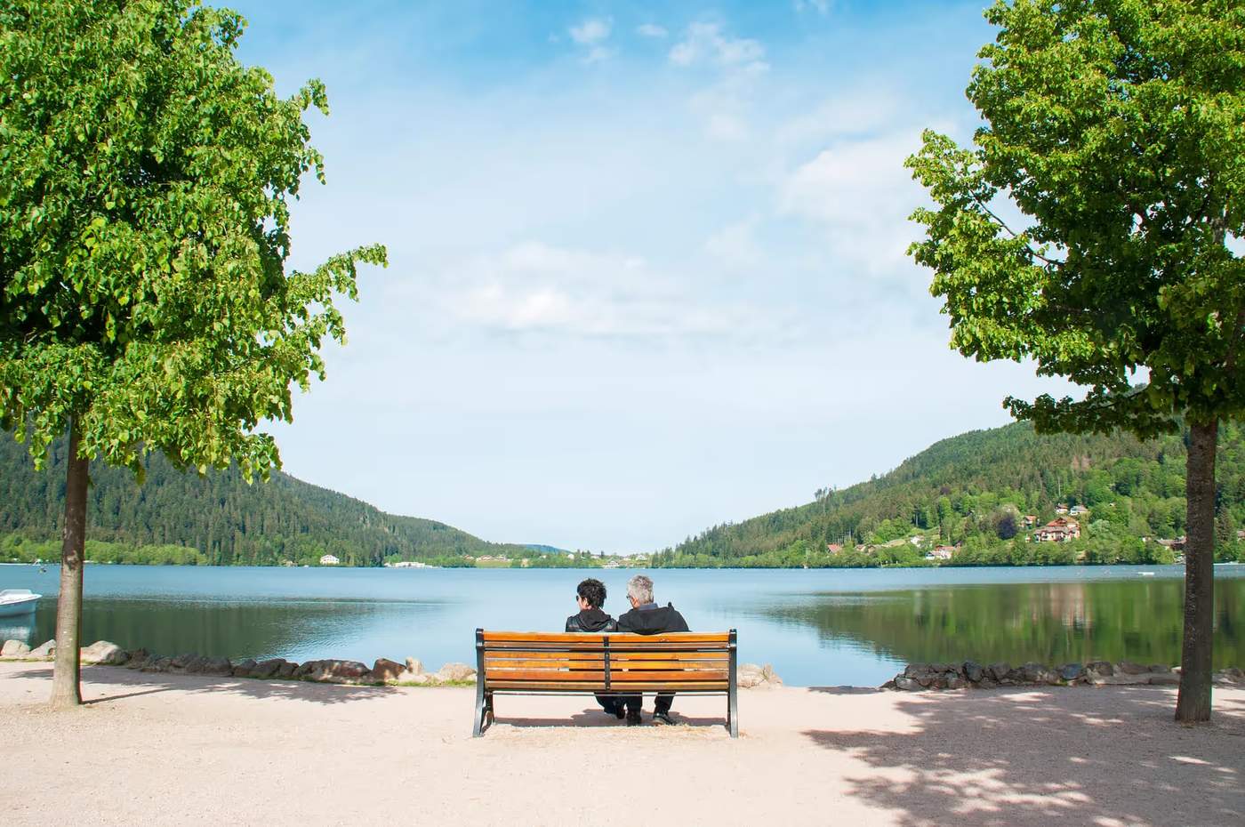 Des personnes assises sur un banc en face du lac de Gérardmer