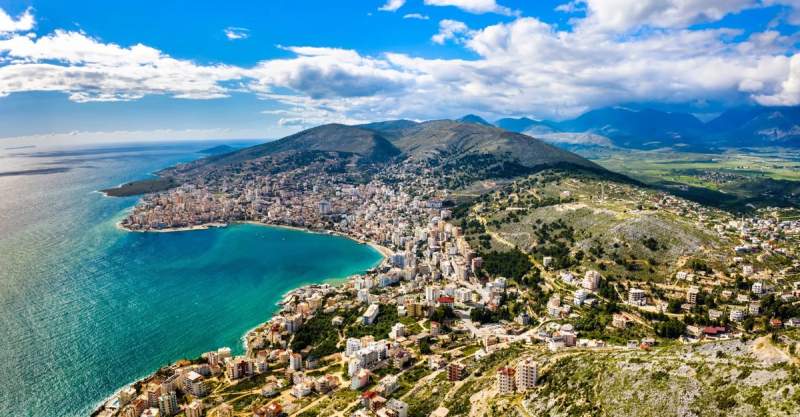Vue panoramique sur Saranda, une ville côtière albanaise bordée par la mer Ionienne, avec ses collines environnantes et ses plages pittoresques.