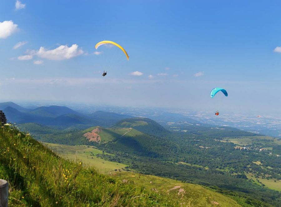 Deux parapentes survolant les montagnes verdoyantes de l