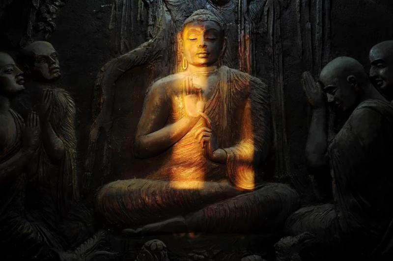 Relief sculpté représentant Bouddha en méditation, éclairé par une lumière dorée, à Kandy au Sri Lanka.