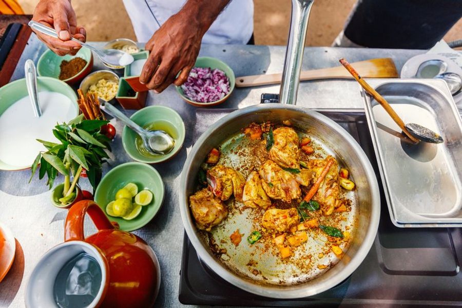 Un chef sri-lankais prépare un curry épicé avec des ingrédients locaux lors d’un cours de cuisine à Hiriketiya.