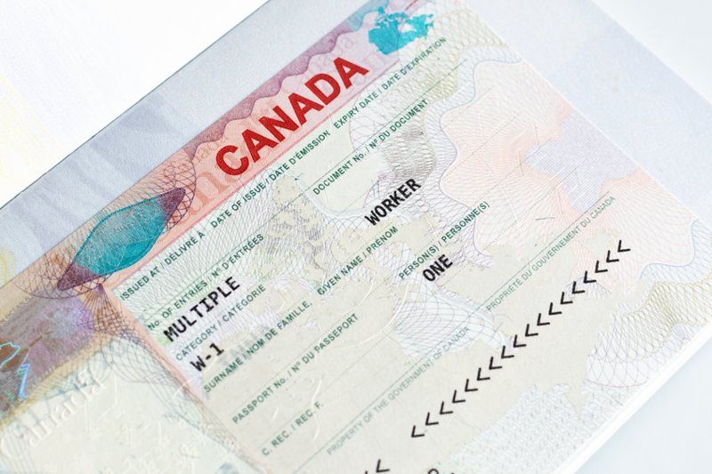Visa de travail canadien collé dans un passeport, indiquant une autorisation multiple.