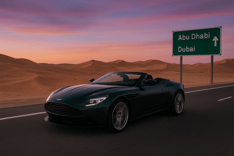 Aston Martin cabriolet roulant entre Abu Dhabi et Dubaï au coucher du soleil, sur une route désertique bordée de dunes.