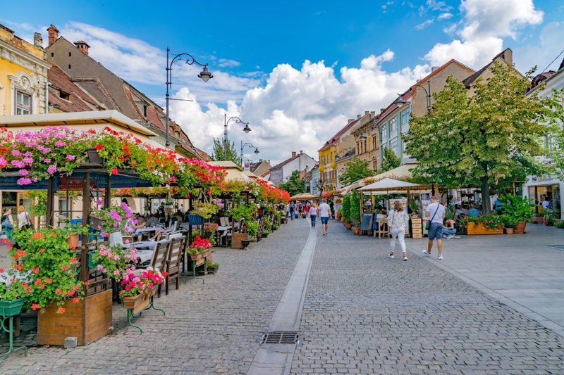 Rue Nicolae Bălcescu à Sibiu, Roumanie, avec ses terrasses et fleurs en été.