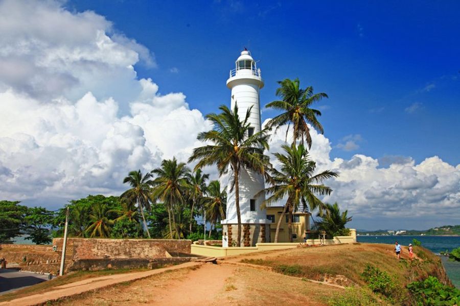 Phare blanc entouré de palmiers dans le fort de Galle
