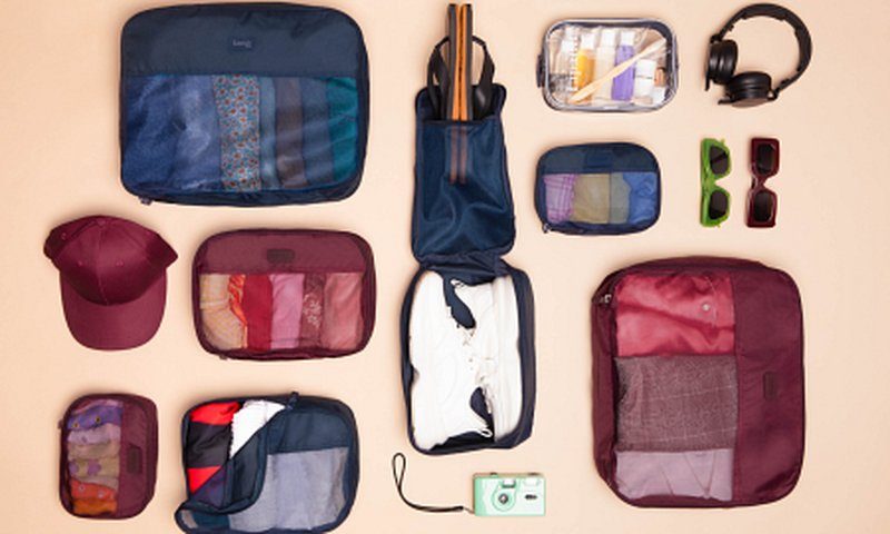 Organisateurs de bagages et accessoires de voyage disposés à plat pour préparer un road trip