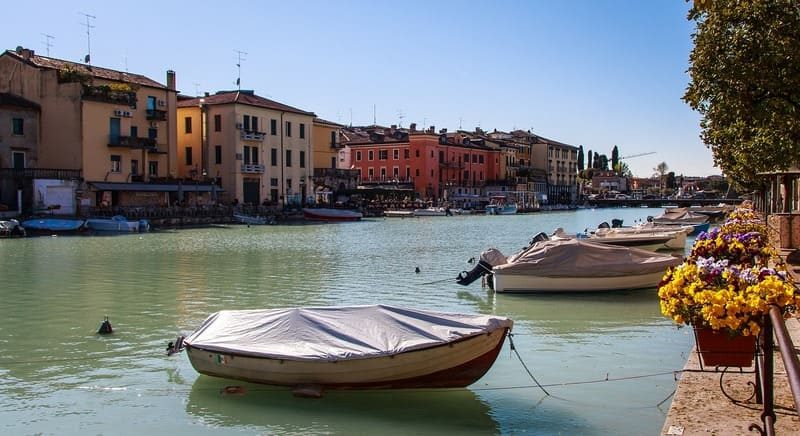 Canal tranquille bordé de bateaux à Peschiera del Garda, Italie