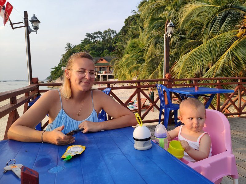 Moment en famille autour d’une table avec vue sur la plage et les cocotiers à Perhentian Besar.