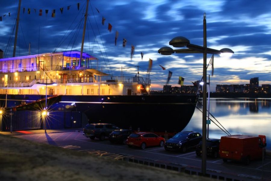 Le Royal Yacht Britannia illuminé de nuit, amarré à Leith où il est devenu un musée flottant à Édimbourg.