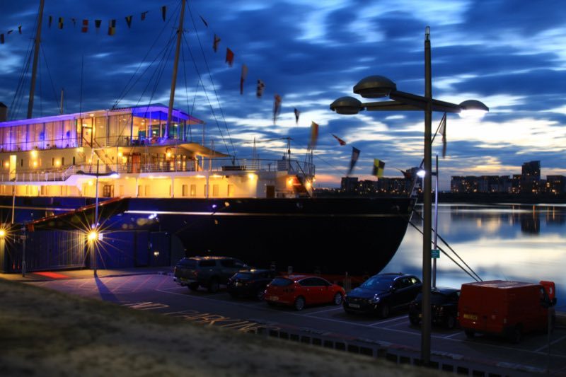 Le Royal Yacht Britannia illuminé de nuit, amarré à Leith où il est devenu un musée flottant à Édimbourg.