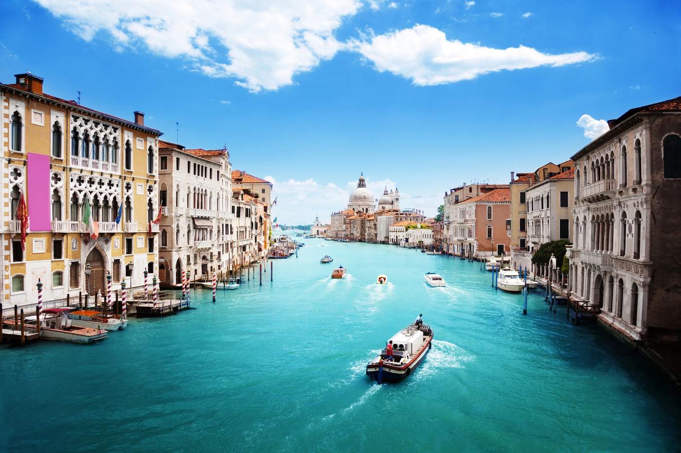Vue du Grand Canal à Venise par temps clair, avec bateaux et la basilique Santa Maria della Salute au fond