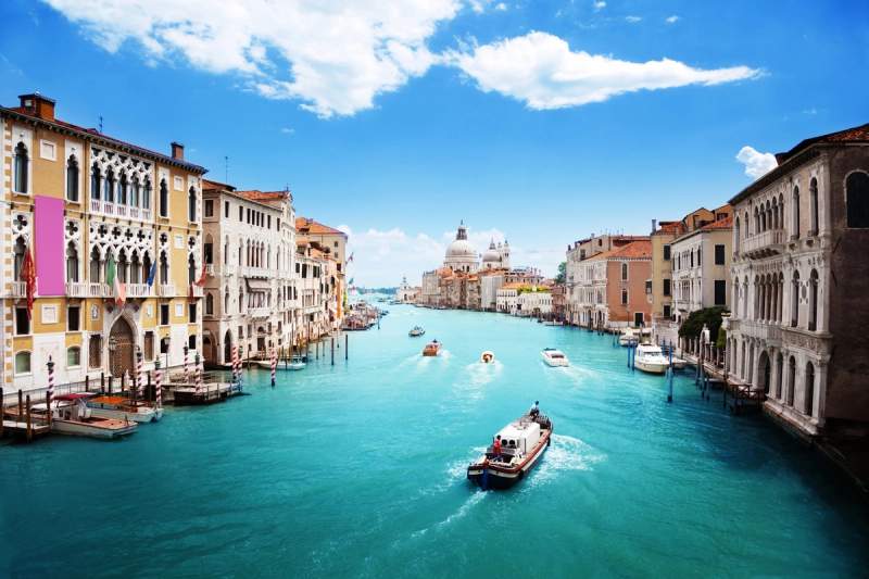 Vue du Grand Canal à Venise par temps clair, avec bateaux et la basilique Santa Maria della Salute au fond