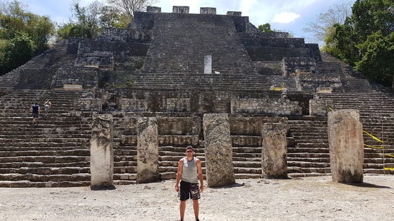 Un homme debout au sommet de la structure II à Calakmul, surplombant un océan de canopée verte à perte de vue