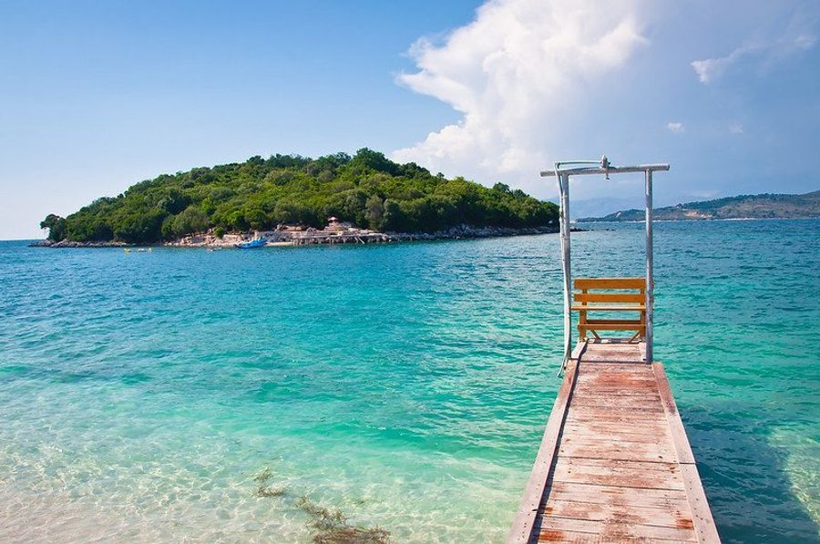 Plage de Ksamil avec son île verdoyante et ses eaux claires.