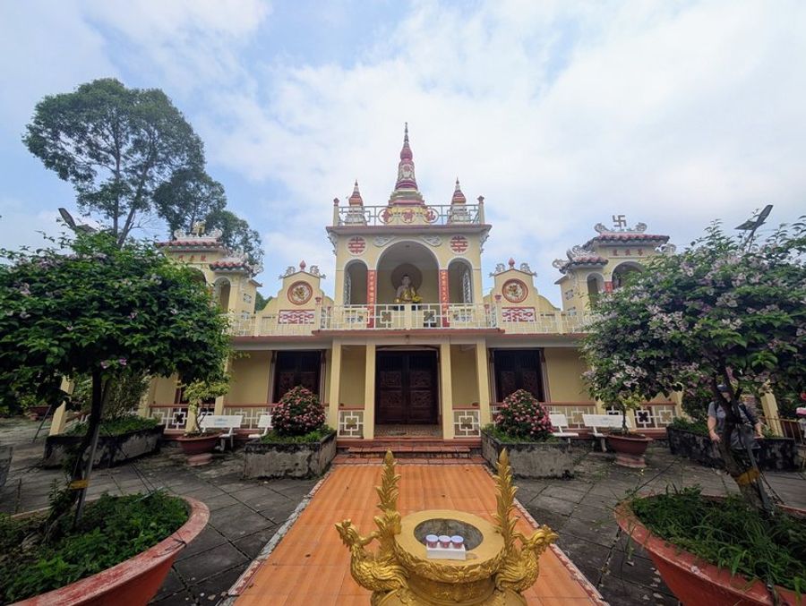 Entrée de la pagode de Tien Chau à Vinh Long, décorée de motifs traditionnels et entourée de végétation