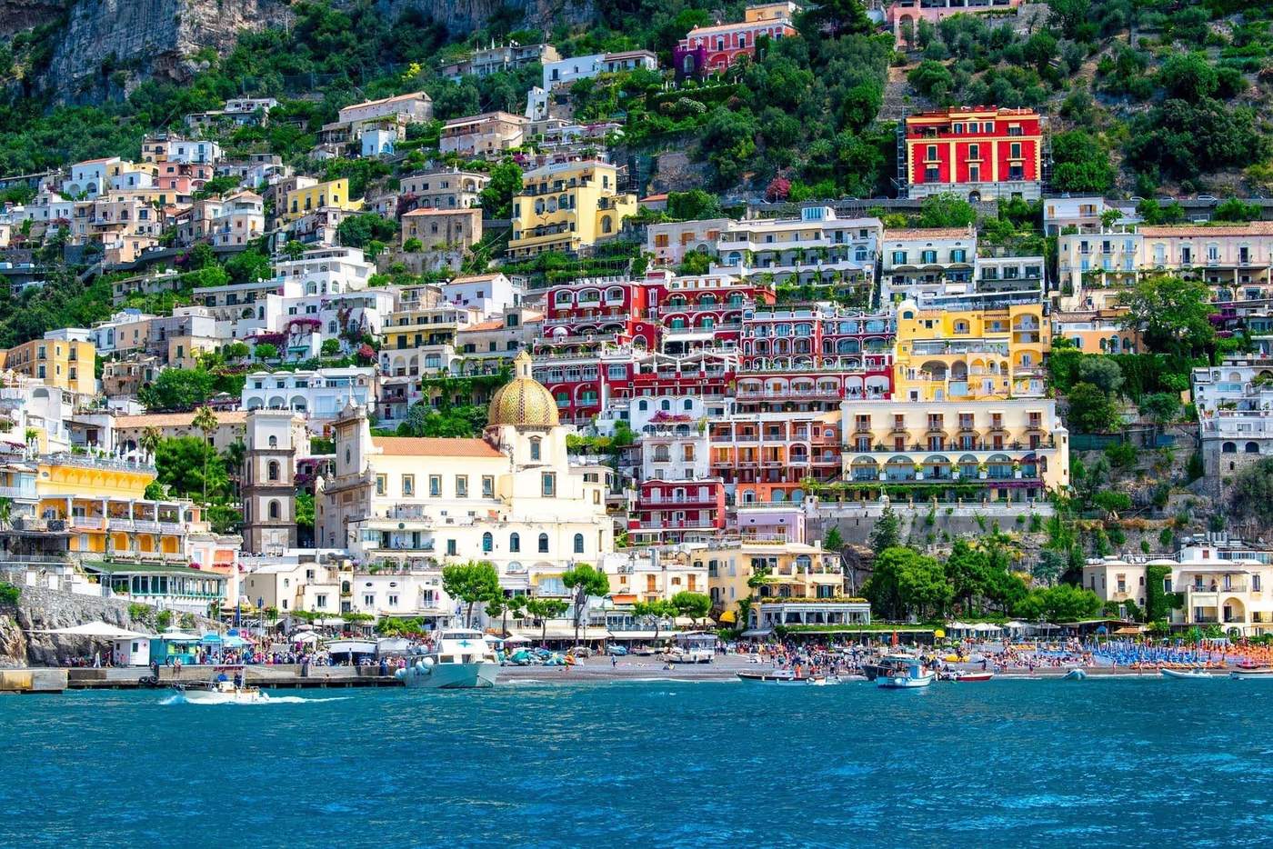 Vue panoramique de Positano sur la côte amalfitaine avec ses maisons colorées et la mer en avant-plan.