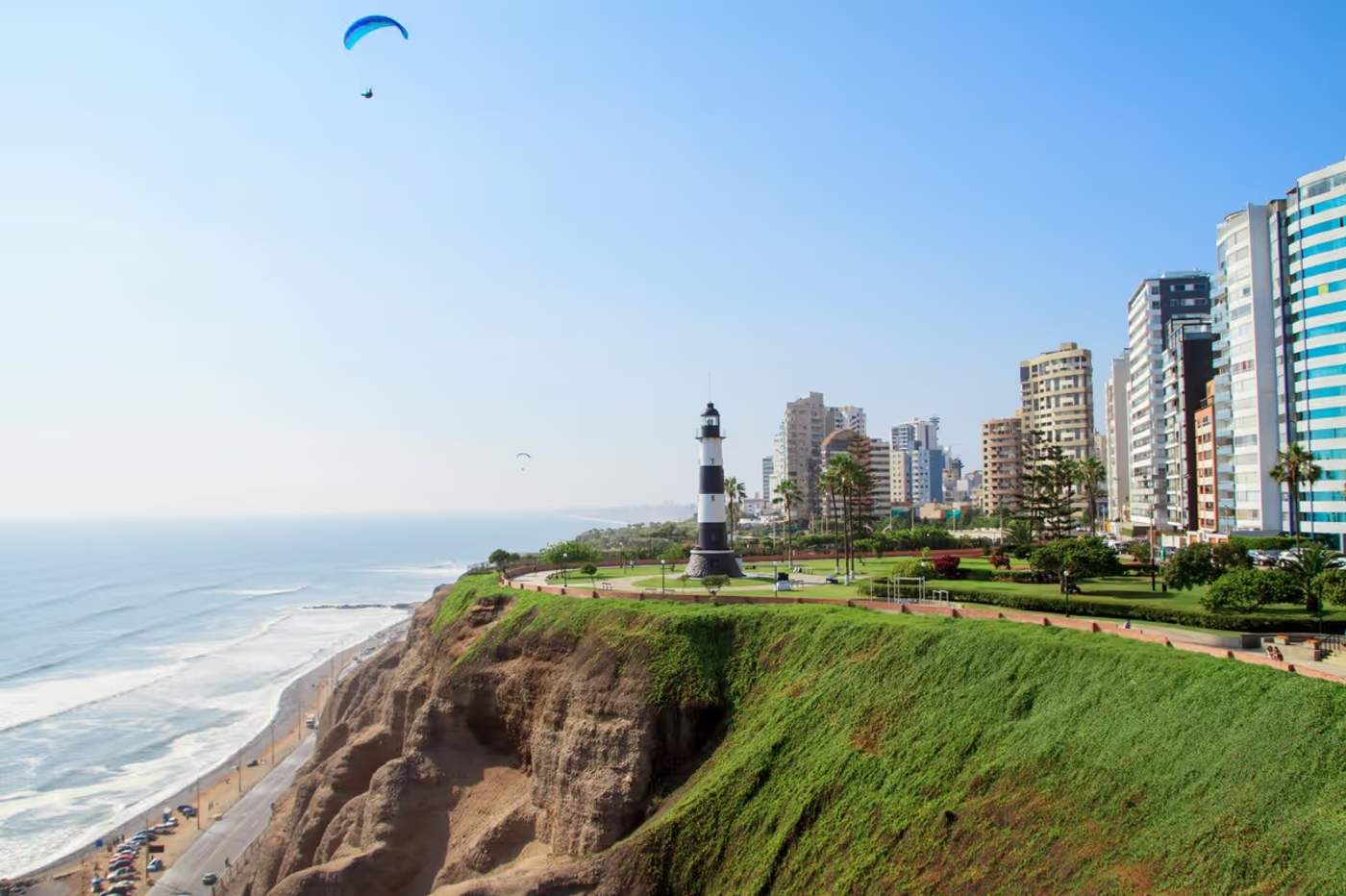 Parapente au-dessus du phare de Miraflores à Lima avec vue sur l’océan Pacifique et les falaises verdoyantes