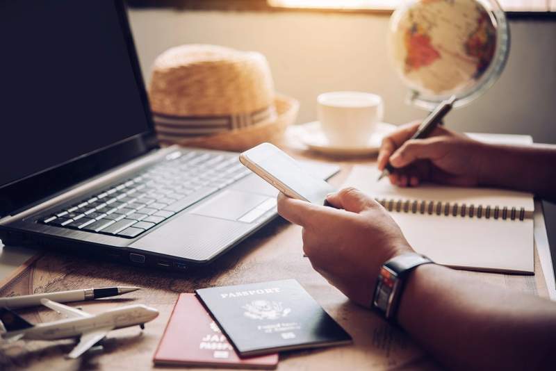 Planification d'un voyage au Canada sur mesure : passeports, carnet de notes et smartphone sur un bureau de voyageur